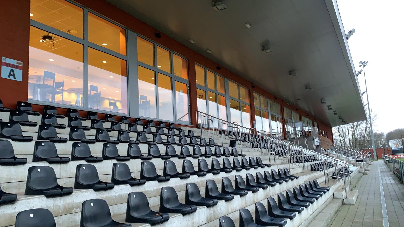 Tribune met grote glaspartijen aan een sportterrein