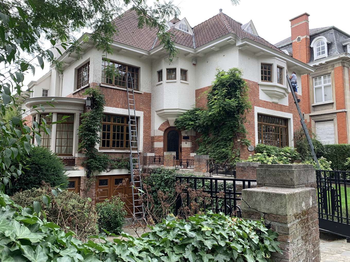 Herenwoning met ramen die gewassen worden, met ladder tegen de gevel